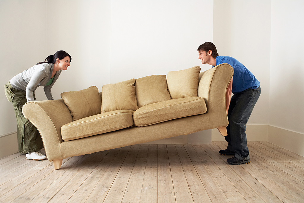 man and a women pick up sofa